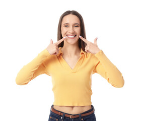Young woman pointing at her smile on white background