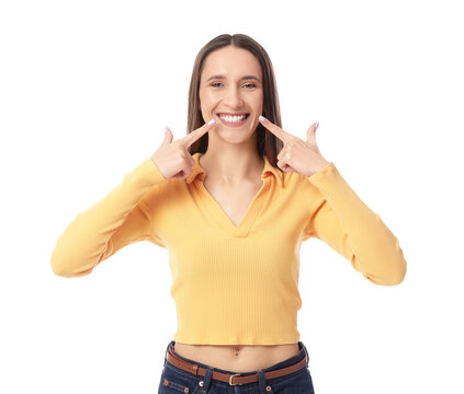 Fototapeta Young woman pointing at her smile on white background