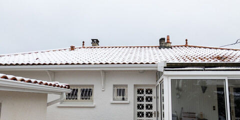 roof of a detached house with a thin layer of snow on building