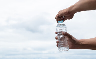 水のペットボトルを開ける人