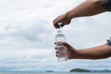 水のペットボトルを開ける人