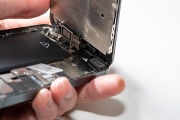 The smartphone was damages and need to repair  which tools smartphone that stand on white background by hands of repairman.
