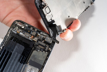 The smartphone was damages and need to repair  which tools smartphone that stand on white background by hands of repairman.
