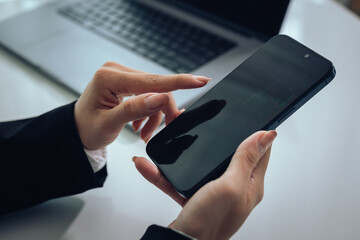 An investor monitors real-time stock market data on a smartphone and laptop, analyzing charts, financial trends, and cryptocurrency for informed trading decisions in a digital workspace.