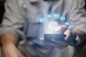Close-up of man's hand using smartphone to play social media with emoticons or notifications popup.	
