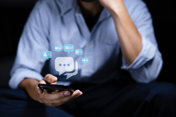 Close-up of man's hand using smartphone to play social media with emoticons or notifications popup.	
