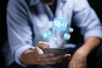 Close-up of man's hand using smartphone to play social media with emoticons or notifications popup.	
