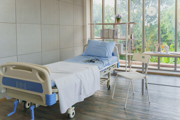 An empty hospital room with a modern bed, suggesting recovery, waiting, or healthcare facilities. A clean and bright patient room in a clinic or hospital, with a tablet and stethoscope on the bed.