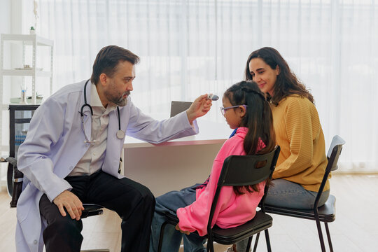 Doctor performing a neurological examination on a child patient using a reflex hammer. Pediatrician checking a young girl's temperature with a digital thermometer during a clinic visit. - Powered by Adobe