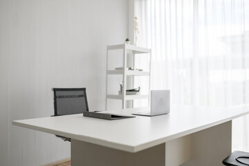 Modern and minimalist empty doctor's office or consultation room with a white desk and chairs. Clean and professional workspace interior, suitable for a clinic, office, or job interview setting.