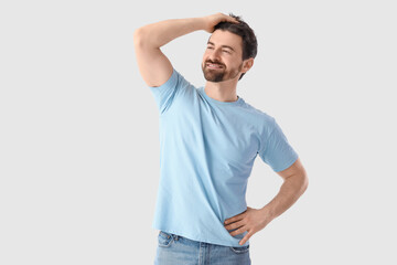 Happy man after hair loss treatment on light background