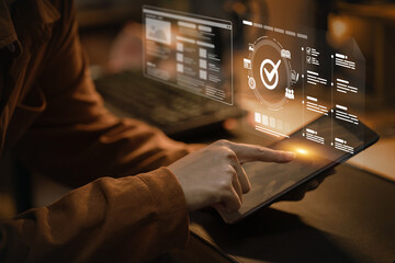 A person uses a tablet with a project management dashboard, tracking tasks and team progress to...