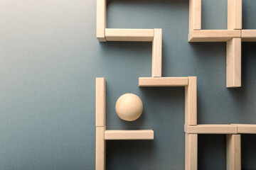 A wooden ball navigating through a maze, symbolizing clarity, breakthrough, and emerging from confusion or challenge toward success