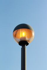 street lamp on blue sky. one night lamp post shines with a faint light on a blue background 
