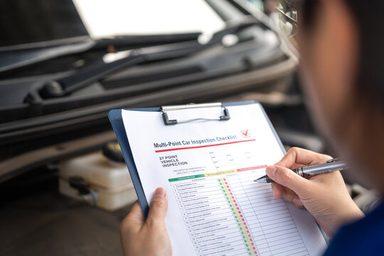 Action of a repairman is checking on multi-point checklist form during perform service the car parts. Industrial working scene, close-up and selective focus. - Powered by Adobe