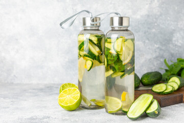 Cucumber water with lemon, lime and mint on a wooden table. Water infused with sliced...