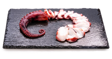 Closeup,Raw Tentacles of octopus on black plate on white background, kraken tentacles with suckers isolate on white with clipping path.