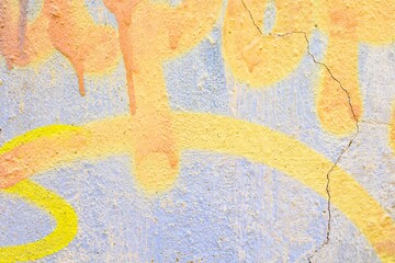 Textured wall with pastel yellow, blue spray paint graffiti, urban art style. 90s vibe, crackle...