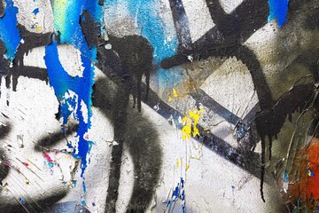 Dynamic urban graffiti composition with bold colors like blue, yellow, black on a textured wall....
