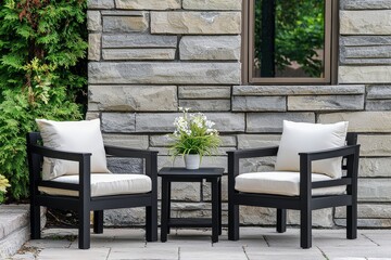 Fototapeta premium Three-piece patio furniture set with black wood frame and cream cushions, including two chairs and a table for outdoor use.