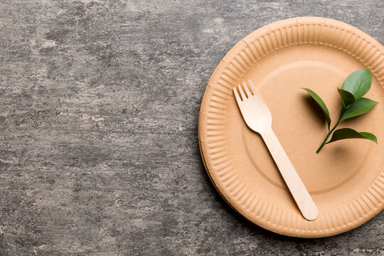 set of empty reusable disposable eco-friendly plates, cups, utensils on light white colored table background. top view. Biodegradable craft dishes. Recycling concept. Close-up
