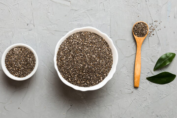Chia seeds in bowl and spoon on colored background. Healthy Salvia hispanica in small bowl. Healthy...