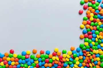 Mixed collection of colorful candy, on colored background. Flat lay, top view. frame of colorful chocolate coated candy
