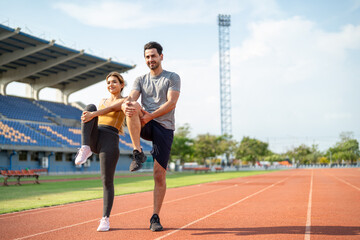 Obraz premium Diverse young man and woman athletes exercising together at stadium. 