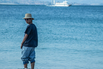 casual young man strolling along the beach shore