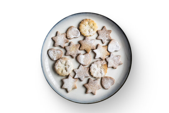 A plate of assorted star and heart-shaped cookies dusted with powdered sugar. - Powered by Adobe