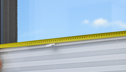 Metal tape measure, measuring a window at home