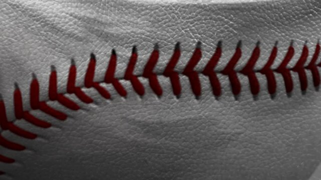 Close-up of red stitching on white leather baseball surface. Macro detail of classic sports equipment texture, ideal for backgrounds, baseball themes, or athletic design compositions.