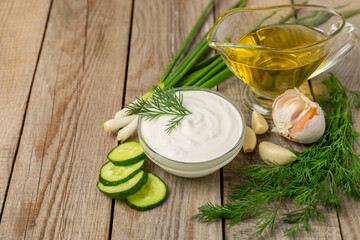 Cucumber sour cream tzatziki sauce on a wooden table.Tartar sauce. Traditional delicious appetizer....