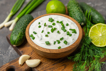 Cucumber sour cream tzatziki sauce on a wooden table.Tartar sauce. Traditional delicious appetizer....