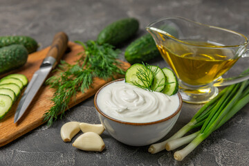 Cucumber sour cream tzatziki sauce on a wooden table.Tartar sauce. Traditional delicious appetizer. yogurt sauce. Tzatziki with ingredients cucumber, garlic,dill,lemon,mint. salad dressing.Copy space