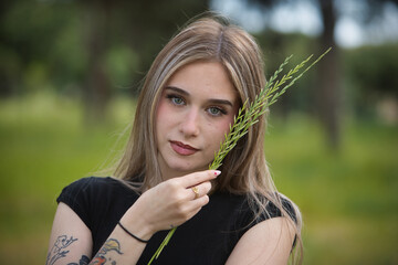 Portrait of a young woman, beautiful, blonde, green eyes, wearing a black t-shirt, sweet and...