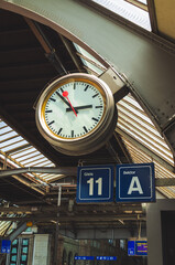 Large clock inside train main station in a European city.