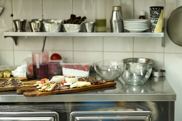 Assorted gourmet cold cuts, cheeses, and appetizers arranged on a wooden board in a professional...