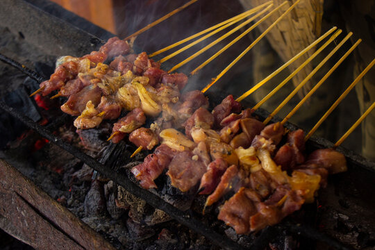 sate kambing or satay goat, lamb, Lamb or meat goat satay with charcoal ingredient on red fire grilling by people. traditional satay from yogyakarta, java, Indonesia cooking satay