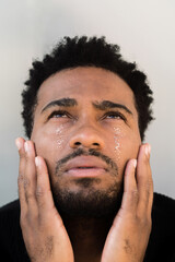 Man with glitter tears looking up