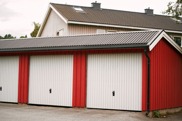 Naklejka premium Red garage units with white doors in a suburban area