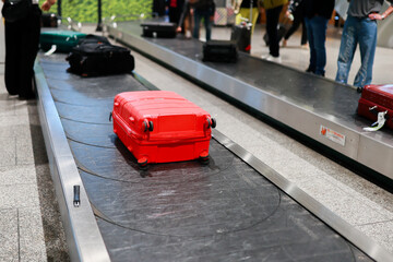 A suitcase moves along the baggage carousel at an airport. The image captures a typical moment of air travel, representing arrival, luggage claim, and the travel experience. © Kateryna