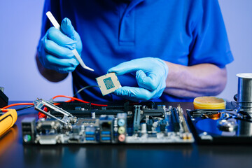 Technician with gloves installs CPU on motherboard using tools. High-tech computer repair, DIY...