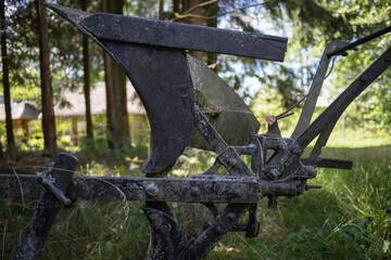 A rusty plow is sitting in a field