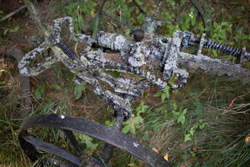 An old, rusted piece of machinery with a black wheel and a grey handle