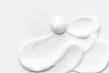 samples of cosmetic care products smear of cream and gel texture on a light background