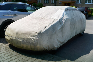 Outdoor parked car hidden under cover