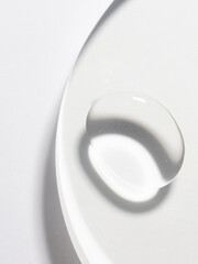 A transparent liquid drop on white background, abstract cosmetic product swatch for market palce