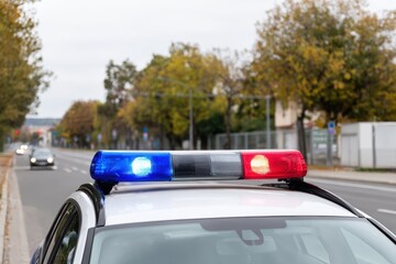 Obraz premium Police car lights at dusk: emergency vehicle in urban environment with blurred background