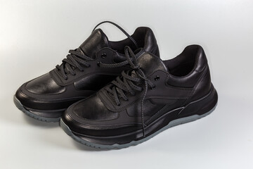Black leather men's sneakers on a gray background